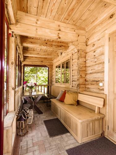 a room with a couch in a log cabin at Baltās anemones in Jumprava