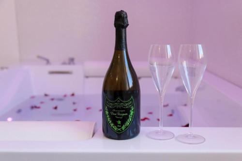 The Smerald 2 في ألغيرو: زجاجة من النبيذ موضوعة على طاولة مع كأسين من النبيذ