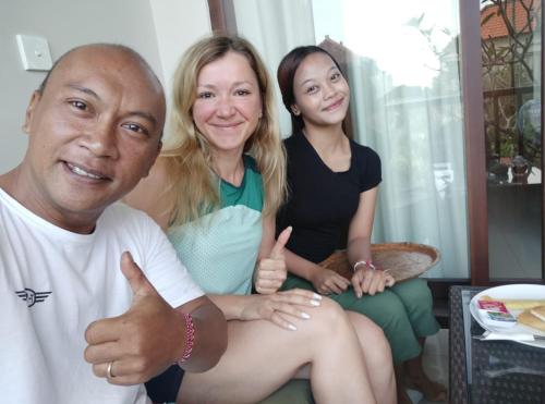 a man and two women giving the thumbs up at ThreeWin Homestay in Ubud