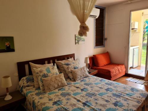1 dormitorio con 1 cama, 1 silla y 1 ventana en Studio Résidence Tobago, en Sainte-Anne