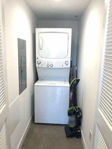 a washer and dryer in a room with a microwave at CasaViva Loft - Modern 2BR with Garage Parking, In-Unit Washer Dryer & ADA Access - Walk to Hillcrest, 5 Min to Gaslamp & North Park in San Diego