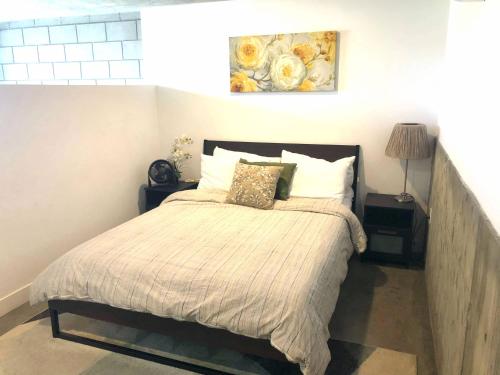 a bedroom with a bed and a painting on the wall at Modern 2 Bdrm w/Parking in the Heart of Hillcrest in San Diego