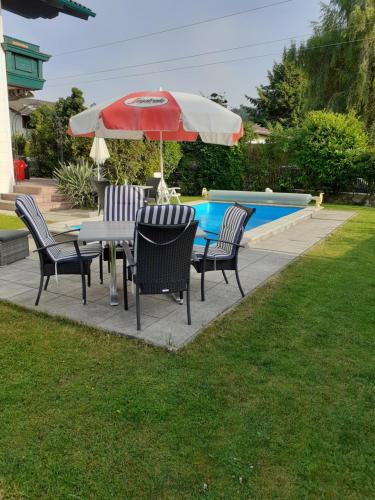 a table and chairs with an umbrella next to a pool at Reitbergs Nest in Eugendorf