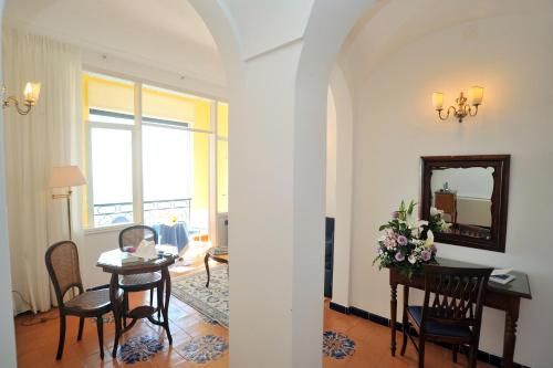 a living room with a table and chairs and a mirror at Hotel Belvedere in Conca dei Marini