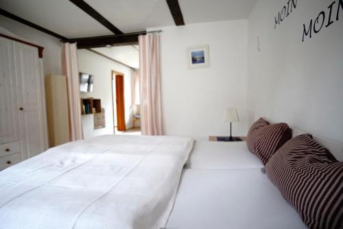 a large white bed in a white bedroom at Fischerhus In Krummin - nur für Urlauber in Krummin