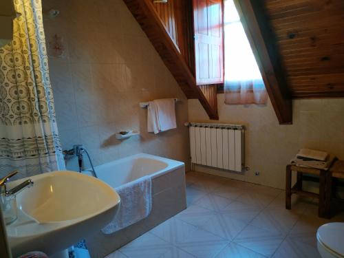 a bathroom with a bath tub and a sink at Pension casat in Salardú