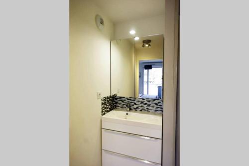 a bathroom with a sink and a mirror at T2 moderne, lumineux, proche de la mer et des principaux accès routiers in Saint-Nazaire