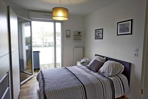 1 dormitorio con cama y ventana grande en T2 moderne, lumineux, proche de la mer et des principaux accès routiers en Saint-Nazaire