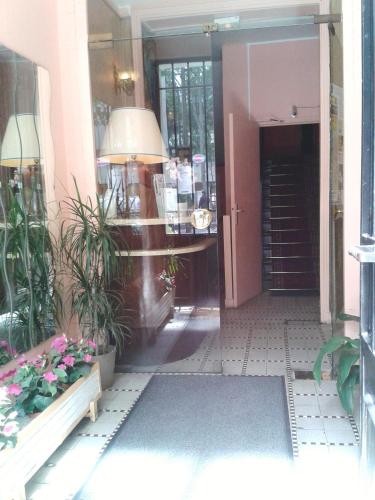 an entrance to a building with a hallway with plants at Hôtel Printania in Boulogne-Billancourt