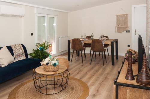 - un salon avec une table et un canapé bleu dans l'établissement Apartamento El Ático, à Astorga