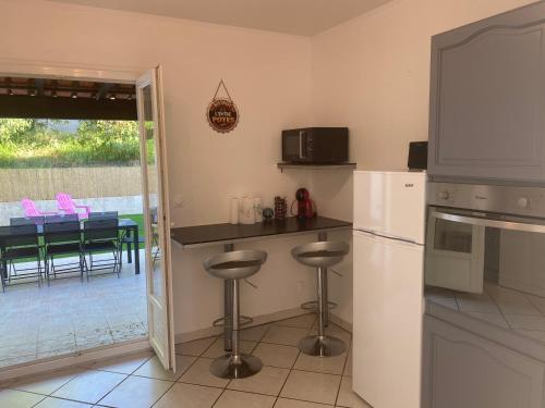 - une cuisine avec un comptoir et des tabourets dans l'établissement La sommieroise, à Sommières