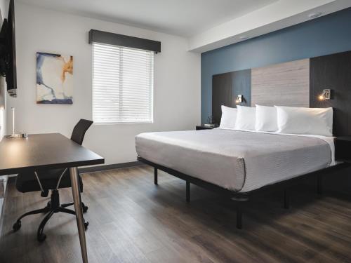 戈茲伯羅的住宿－stayAPT Suites Goldsboro-Seymour Johnson AFB，一间卧室配有一张床、一张桌子和一张桌子