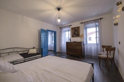 a bedroom with a bed and a dresser and windows at Kuća za odmor Tonka in Grižane