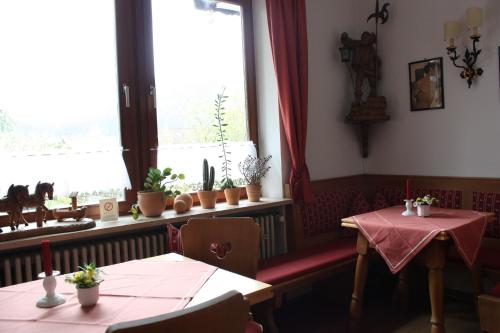 a dining room with two tables and a window at Hotel Garni Otto Huber in Oberammergau