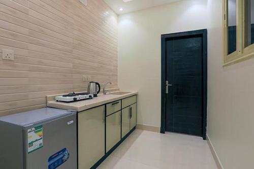 a kitchen with a counter and a black door at فرس ابها للاجنحة الفندقية in Abha