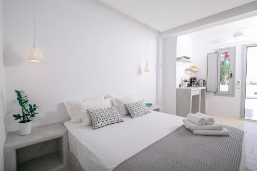 biała sypialnia z dużym białym łóżkiem z poduszkami w obiekcie Sensia Luxury Studio with Hot tub w mieście Oia