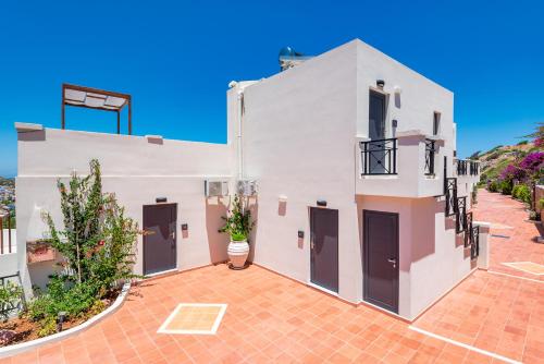 a white house with a red brick courtyard at Minois Boutique Hotel in Stalida