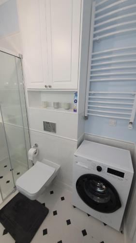 Un baño blanco con inodoro y lavabo. en Apartament Hetmański Zamość Stare Miasto parking podziemny, en Zamość