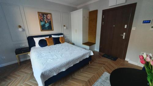 um quarto com uma cama e piso em madeira em Apartament Hetmański Zamość Stare Miasto em Zamość