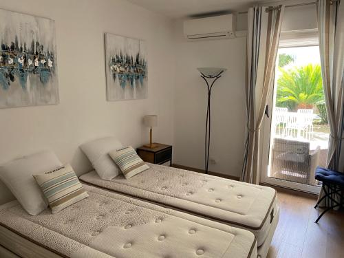 a bedroom with two beds and a large window at Paradise Cannes Center with Pool and Park VILLA LE LYS in Cannes