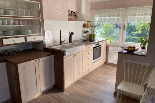 a kitchen with white cabinets and a sink and a window at Grandma's House in Radlje ob Dravi