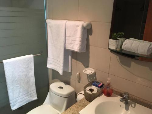 łazienka z toaletą, umywalką i ręcznikami w obiekcie River View Suites Guayaquil w mieście Guayaquil