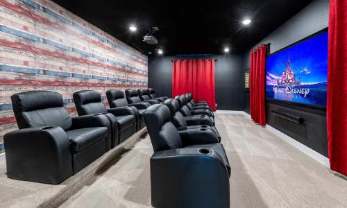 a cinema room with black chairs and a large screen at Gleaming 12 Bdrm Villa With Themed Bedrooms at Encore in Orlando