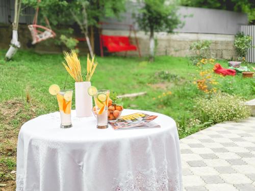 a white table with two glasses and a vase on it at KUTAISI-Maemani in Kutaisi