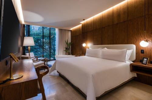 een slaapkamer met een groot wit bed en een bureau bij Elcielo Hotel & Restaurant in Medellín