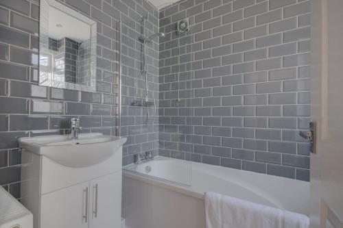 een badkamer met een bad, een wastafel en een spiegel bij Sunderland Self Catering 2 - Violet Cottage Free Parking in Sunderland