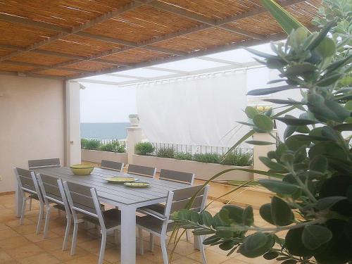 stół i krzesła na patio z widokiem na ocean w obiekcie Casa Marianne w mieście Donnalucata