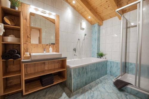 ein Bad mit einer Badewanne, einem Waschbecken und einer Dusche in der Unterkunft Ferienwohnung Stern in Neustift im Stubaital