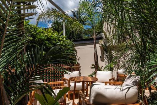 a greenhouse with chairs and tables and plants at Elcielo Hotel Luxury Medellin in Medellín