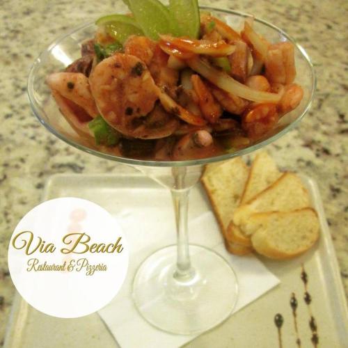 a bowl of food in a wine glass on a table at Tucacas Beach Hotel in Tucacas