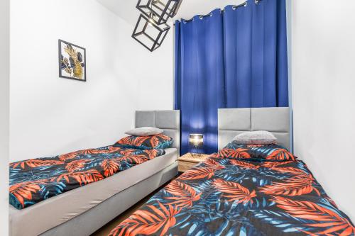 2 letti in una camera con tende blu di Bm apartamenty Wały Chrobrego Radogoska Parking a Stettino