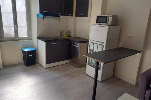 une petite cuisine avec un réfrigérateur et un micro-ondes dans l'établissement F3 5 personnes proche de Paris, à Coubron