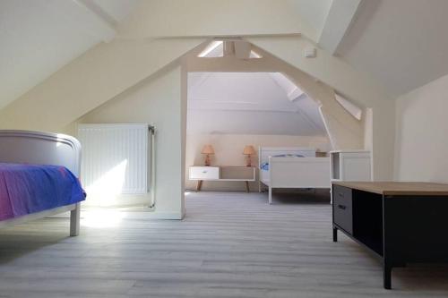 Cette chambre mansardée comprend deux lits et une commode. dans l'établissement F3 5 personnes proche de Paris, à Coubron