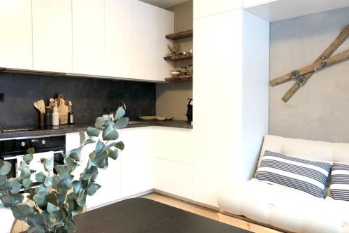 ein Wohnzimmer mit weißen Schränken und einem Kaktus in der Unterkunft Apartmán Strnadovy Boudy in Železná Ruda