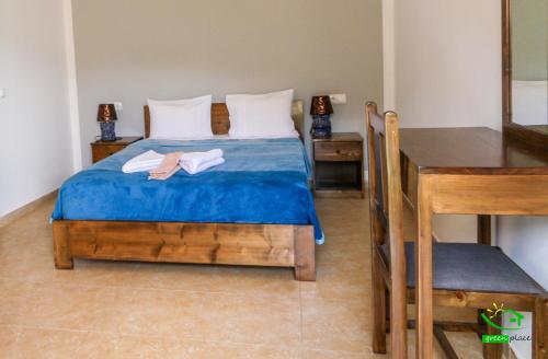 a bedroom with a bed with blue sheets and a table at Pousada Green Place in Ribeira Grande
