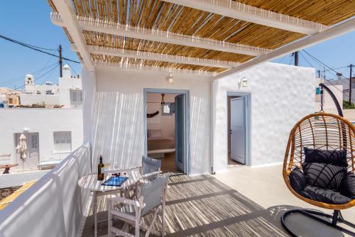 a patio with a table and chairs on a balcony at Plaka Suites in Plaka Milou