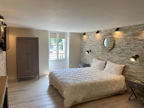 um quarto com uma cama e uma parede de tijolos em Marseille City Chambres&Appartements em Marselha