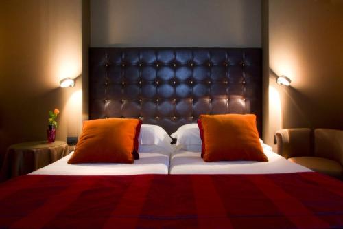 a bedroom with a bed with a leather headboard and two pillows at Marcella Royal Hotel - Rooftop Garden in Rome