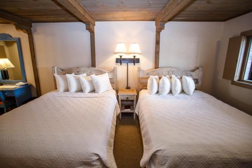 2 camas en una habitación de hotel con 2 lámparas en Chama Trails Motel en Chama