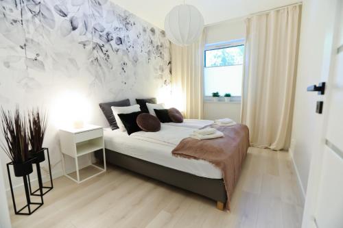 a bedroom with a bed and a window at M&K Apartamenty Cztery Brzozy - Wyspa Sobieszewska in Gdańsk