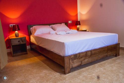 a bedroom with a large bed with a red wall at Pousada Green Place in Ribeira Grande