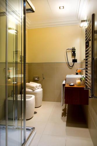 a bathroom with a sink and a toilet and a tub at Marcella Royal Hotel - Rooftop Garden in Rome