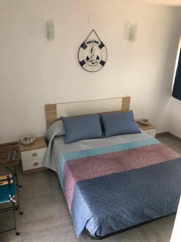 een slaapkamer met 2 bedden en een klok aan de muur bij Apartamento Cervera in Torremolinos