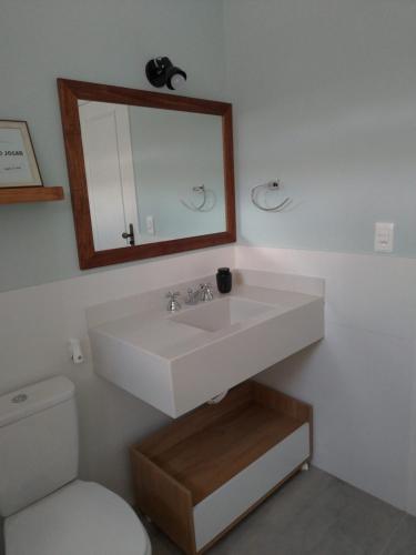 a bathroom with a white sink and a toilet at Casa Verde - Suíte 2 - Iúcas, Teresópolis, RJ in Teresópolis