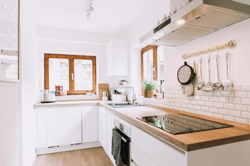 a kitchen with white cabinets and a sink at Mountain Mama Ferienhaus in Schliersee