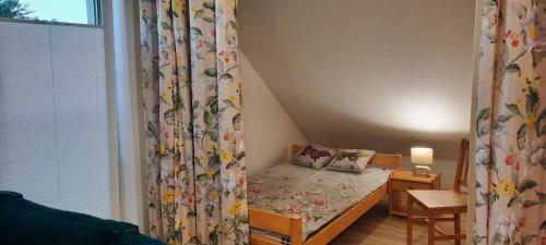 Kleines Zimmer mit einem kleinen Bett und einem Fenster in der Unterkunft Spokojnia Ostróda in Ostróda